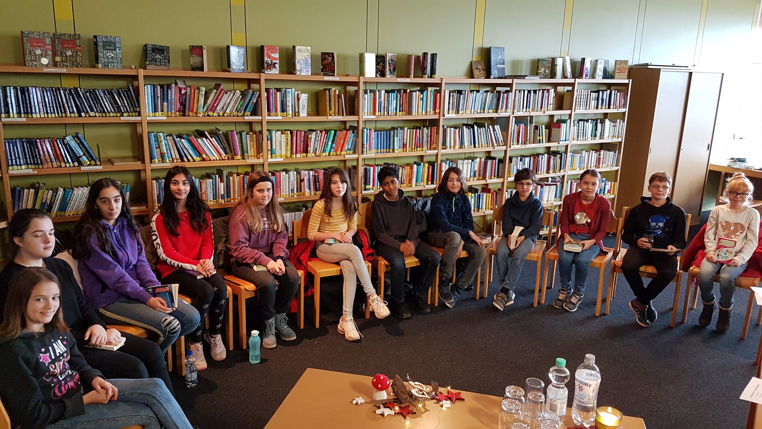Eine Schülerin hält ihre Urkunde „Schulsieger*in“ des Vorlesewettbewerbs vor weihnachtlichen Weihnachtssternen.