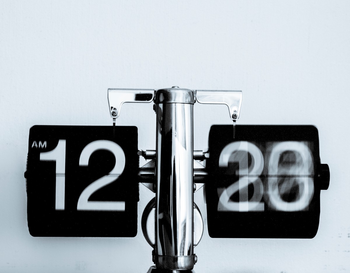 Metallene Hausnummer „17“ auf verwittertem Holz.